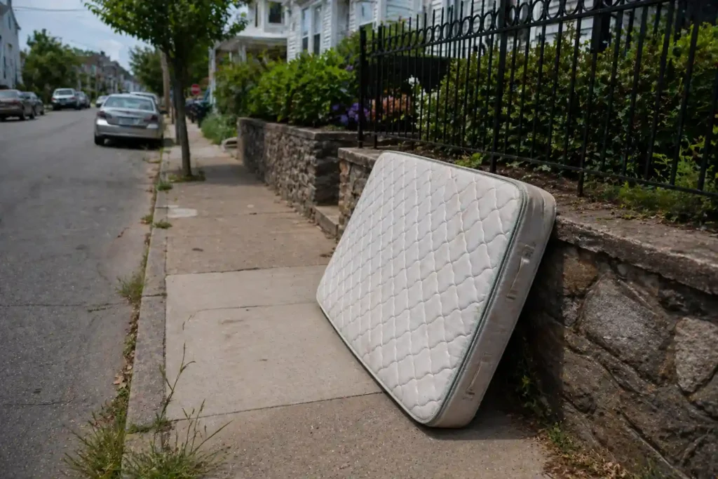 Old mattress placed on sidewalk for disposal in New Bedford MA